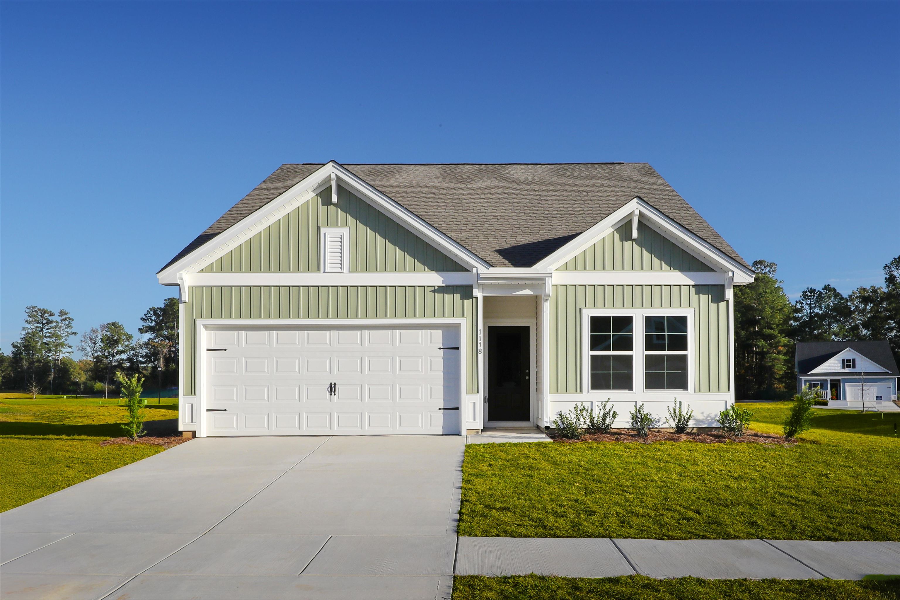 View of front of house featuring roof with shingles, a front yard, concrete driveway, an attached garage, and board and batten siding