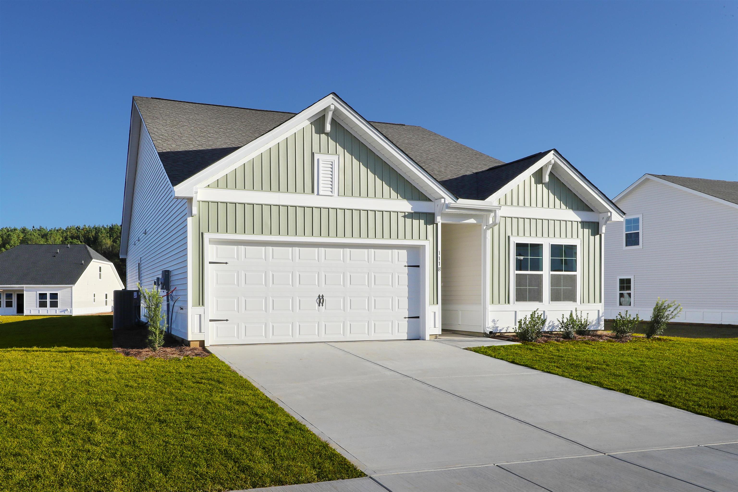 1118 Hainer Place Drive Conway, SC 29526 - Photo 28 of 28 View of front of house with board and batten siding, a front lawn, a shingled roof, concrete driveway, and a garage