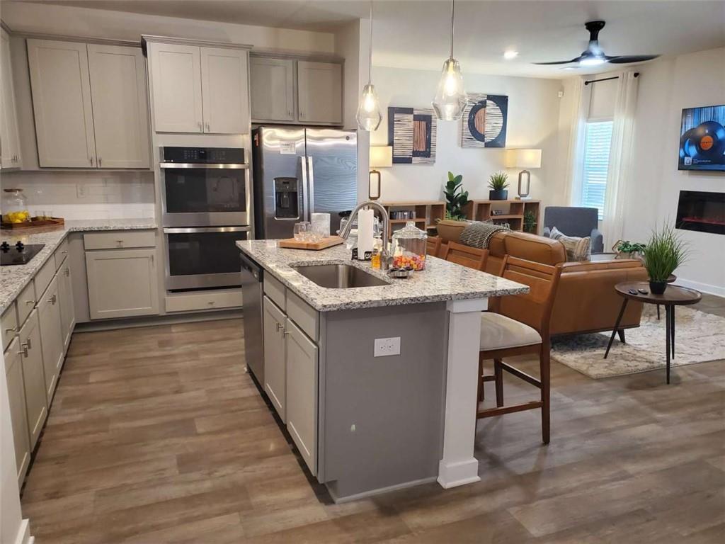5372 Tolar Road South Fulton, GA 30213 - Photo 13 of 26 a kitchen with a sink stove cabinets and wooden floor