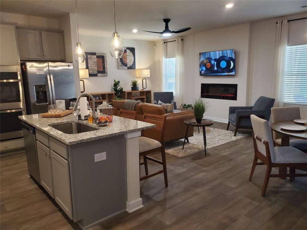 5372 Tolar Road South Fulton, GA 30213 - Photo 15 of 26 a living room with stainless steel appliances kitchen island granite countertop a table chairs and a refrigerator