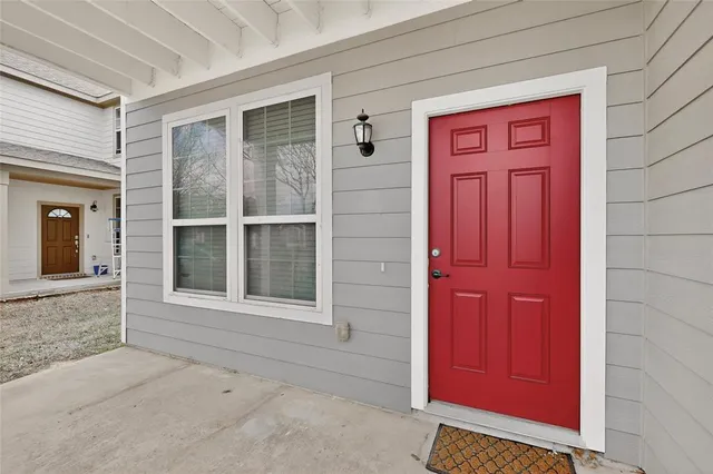 an empty room with chandelier fan and windows