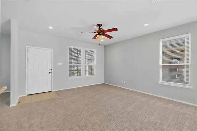 a view of an empty room with a ceiling fan