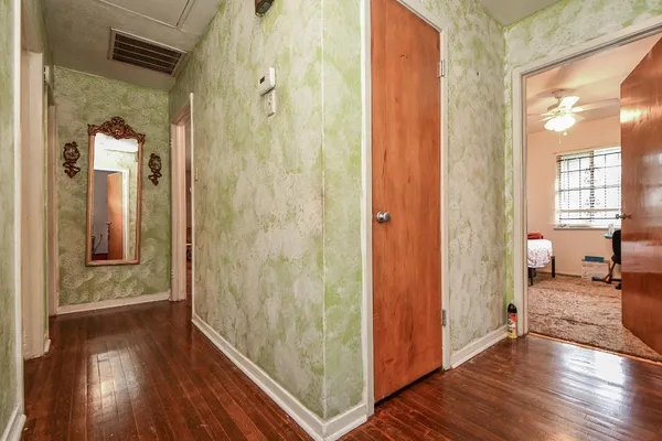 a bedroom with a bed next to a window with the dresser