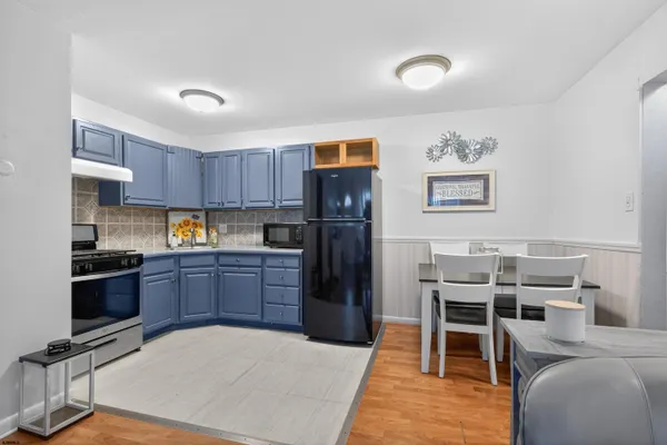 a kitchen with granite countertop a refrigerator stove top oven and sink