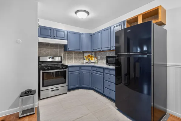 a kitchen with stainless steel appliances granite countertop a refrigerator and a stove