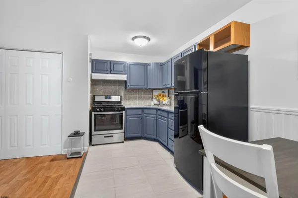 a kitchen with a refrigerator and a stove top oven
