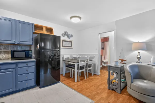 a living room with furniture a flat screen tv and kitchen view