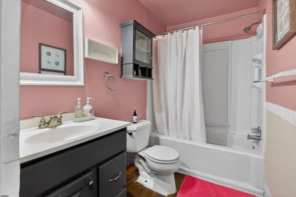 a bathroom with a sink a toilet and shower