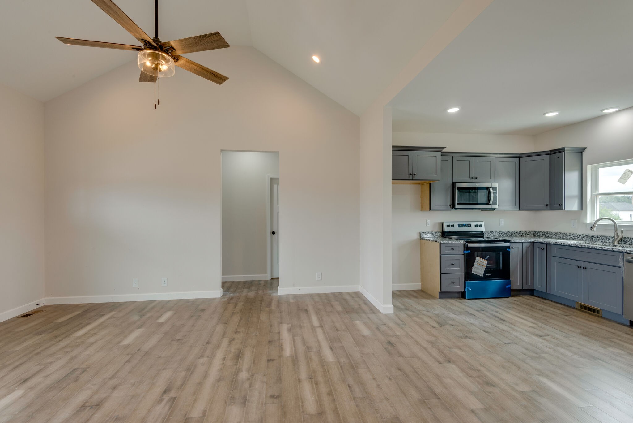 1224 Oak Grove Road Dickson, TN 37055 - Photo 6 of 28 a kitchen with stainless steel appliances granite countertop a refrigerator a sink dishwasher a stove and a microwave oven with wooden floor