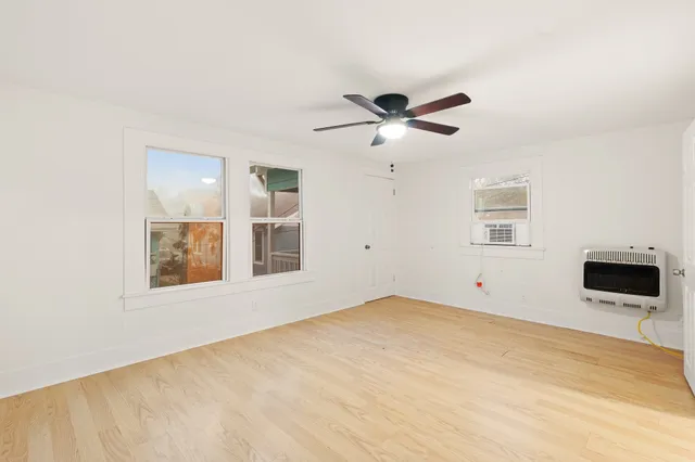 a view of an empty room with a window and a ceiling fan