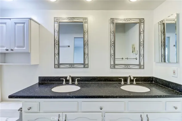 a bathroom with a granite countertop sink and a mirror