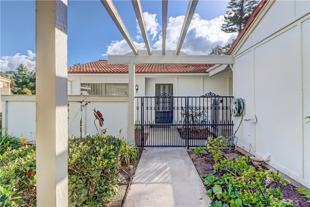 a view of a house with wooden fence next to a yard