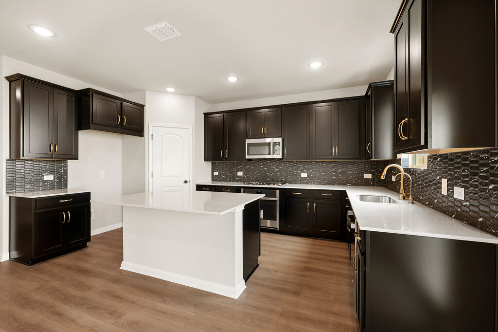 701 Henry Milton Road Georgetown, TX 78626 - Photo 16 of 40 a large kitchen with stainless steel appliances granite countertop a stove a sink and a microwave