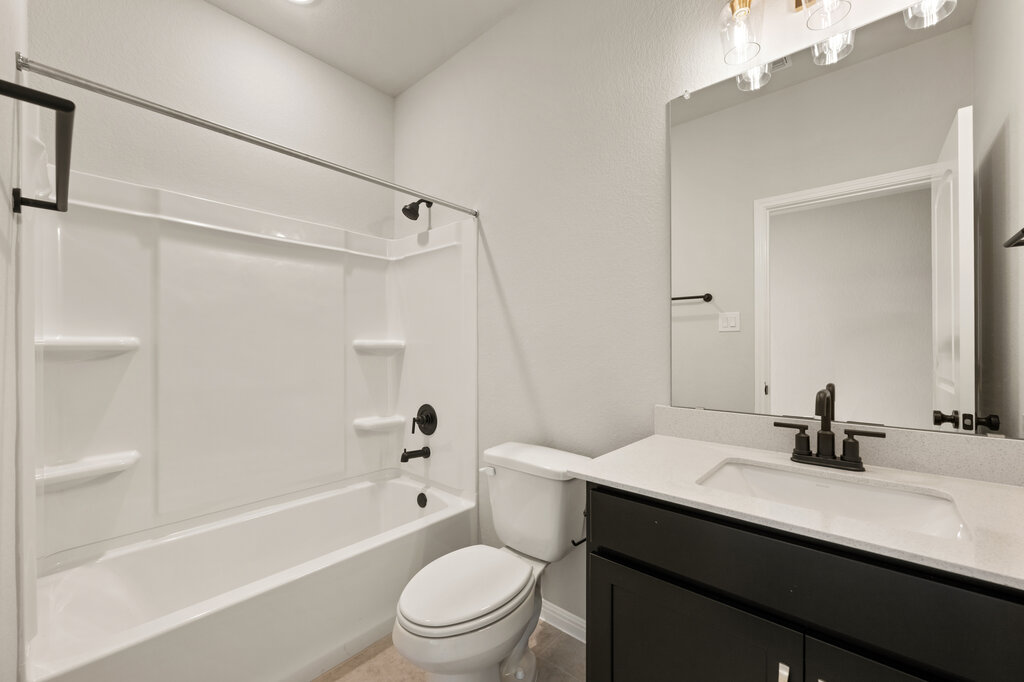 701 Henry Milton Road Georgetown, TX 78626 - Photo 8 of 40 a bathroom with a bathtub shower sink vanity mirror and toilet