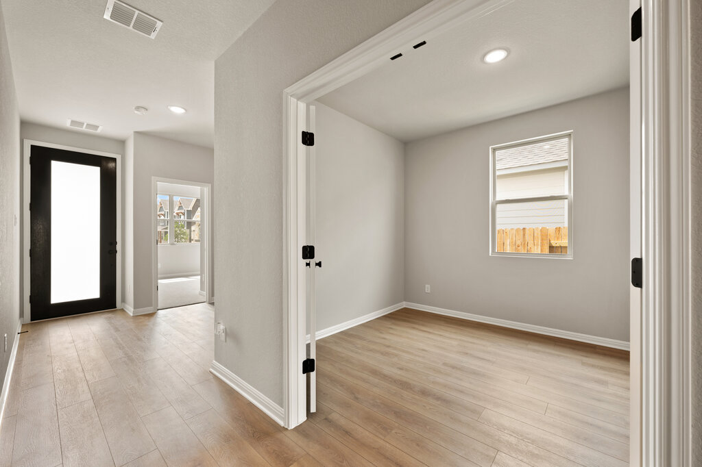 701 Henry Milton Road Georgetown, TX 78626 - Photo 9 of 40 an empty room with wooden floor and windows