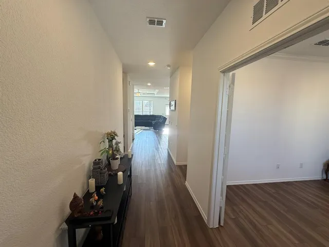 a view of a hallway with wooden floor and staircase