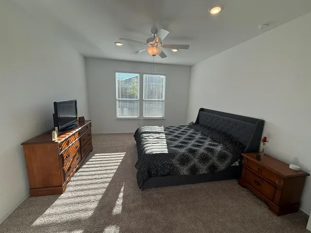 a bedroom with furniture and a flat screen tv