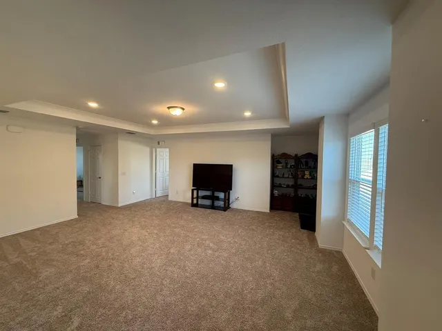 a view of empty room with furniture and window