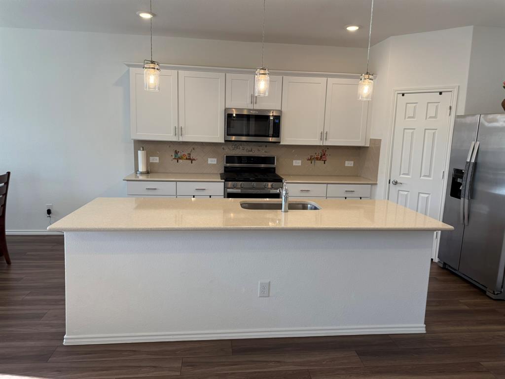 713 Agarita Way Princeton, TX 75407 - Photo 4 of 30 a kitchen with stainless steel appliances a refrigerator stove microwave and cabinets