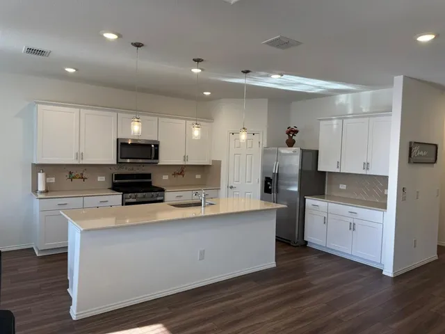 a large kitchen with stainless steel appliances lots of counter top space
