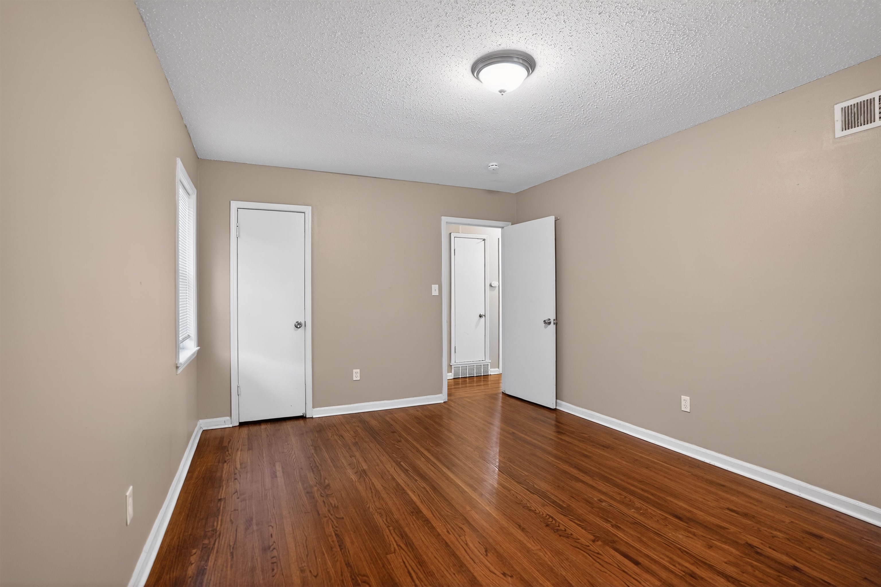 4191 Yale Road Memphis, TN 38128 - Photo 17 of 22 Spacious room featuring wood-finish flooring, neutral-toned walls, a window with white trim, white baseboards, and a ceiling-mounted light fixture