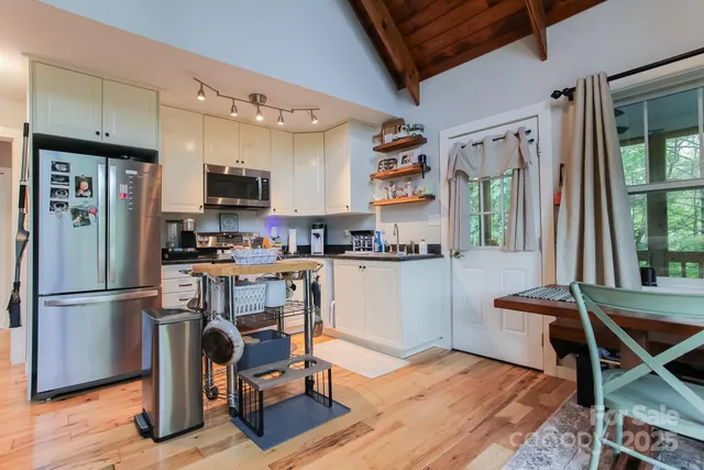a kitchen with stainless steel appliances granite countertop a sink and white cabinets