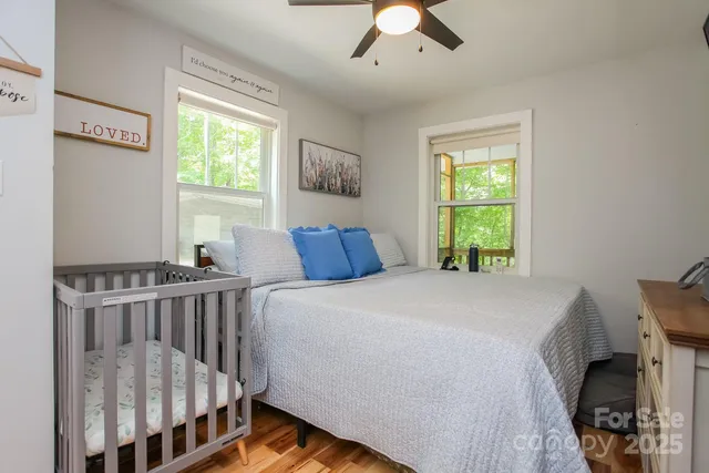 a bedroom with a bed a flat screen tv and windows