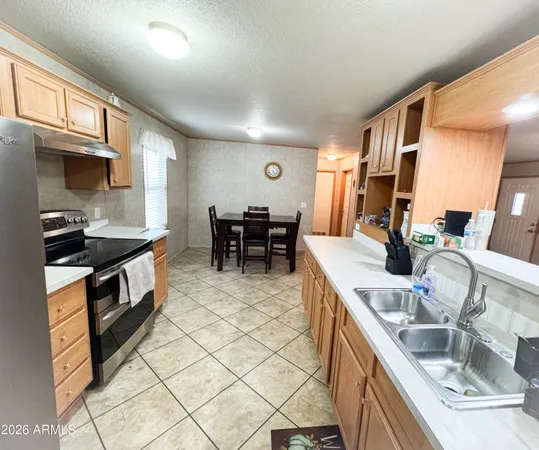 a kitchen with stainless steel appliances granite countertop a sink a stove and a wooden cabinets