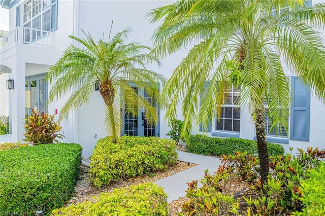 front view of a house with a yard and potted plants