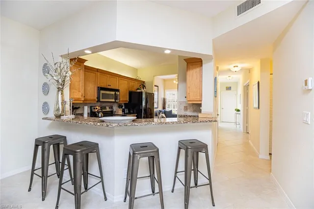 a kitchen with a sink cabinets and chairs