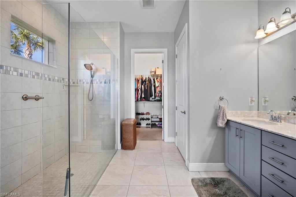 11404 Arezzo Way Fort Myers, FL 33913 - Photo 18 of 36 Bathroom featuring a tile shower, tile patterned floors, and vanity