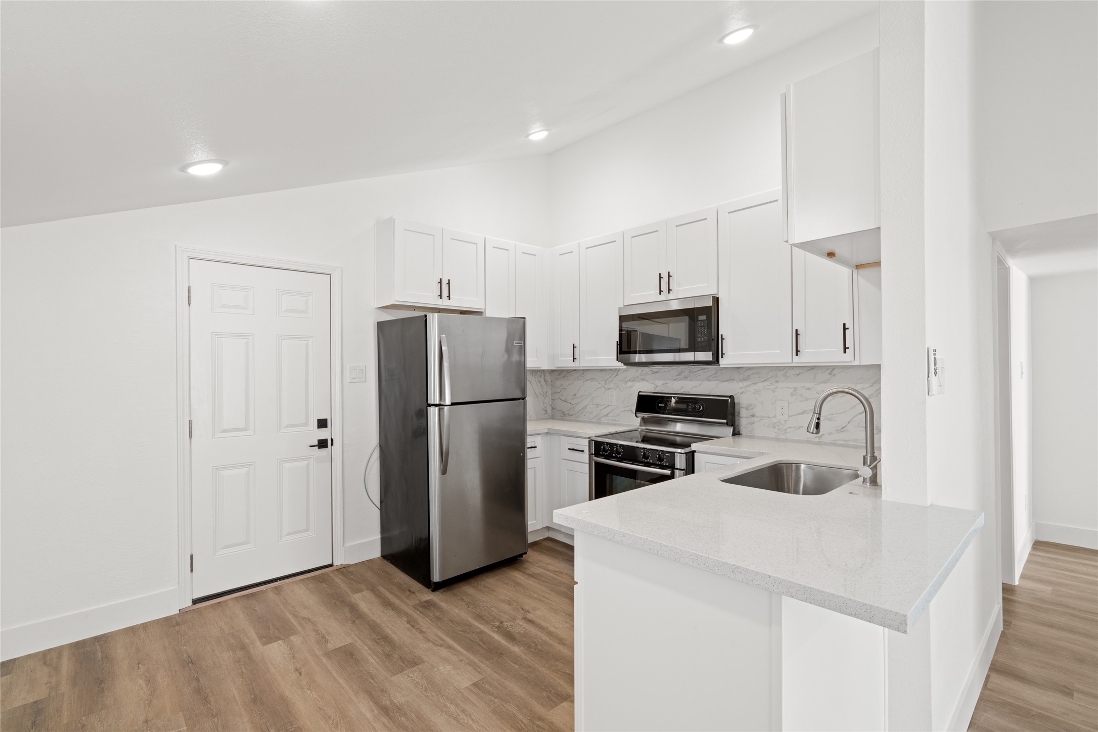 911 Knight Street, Unit D Houston, TX 77022 - Photo 2 of 11 a kitchen with stainless steel appliances a refrigerator stove microwave and sink