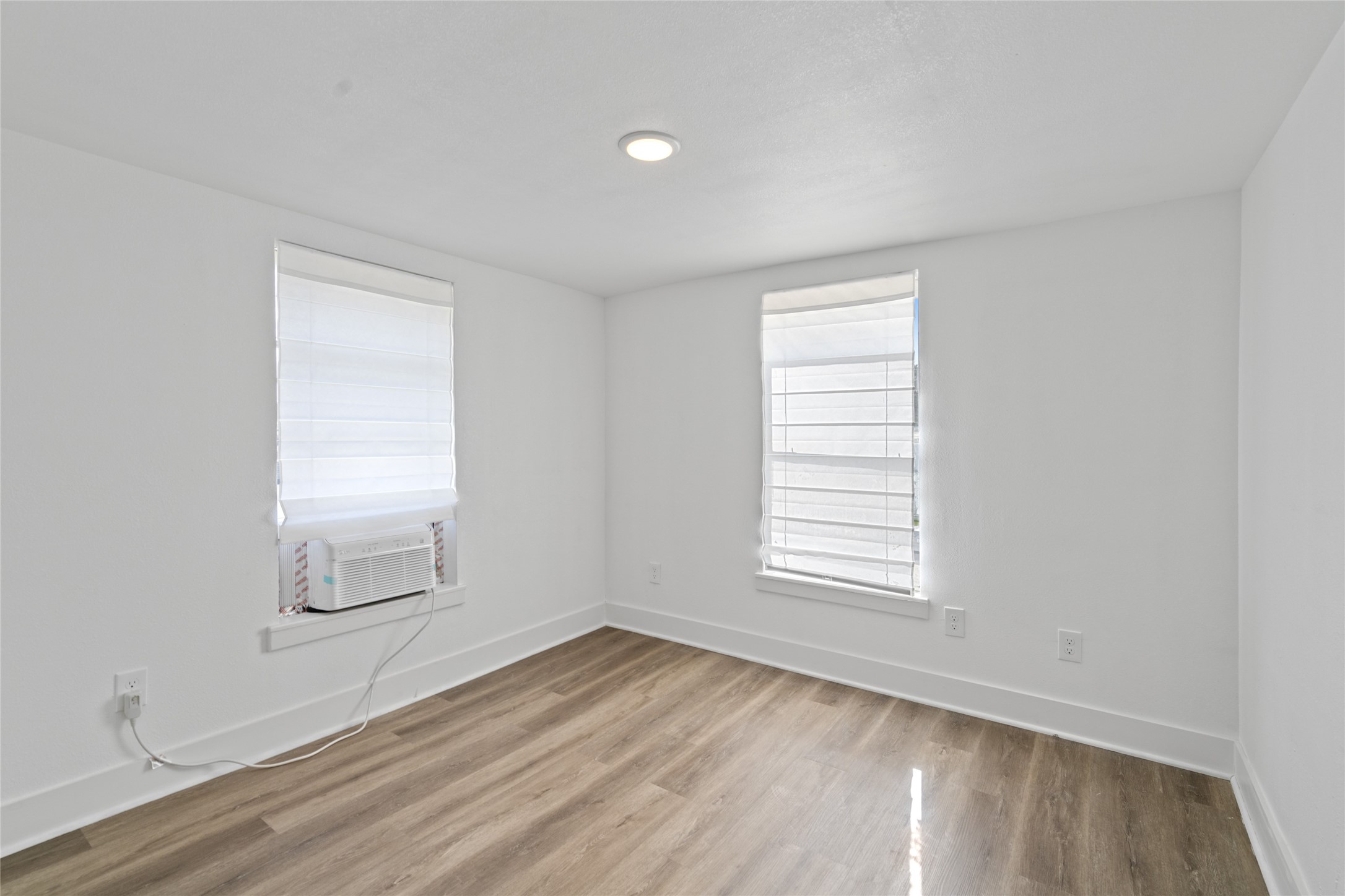 911 Knight Street, Unit D Houston, TX 77022 - Photo 7 of 11 an empty room with wooden floor and windows