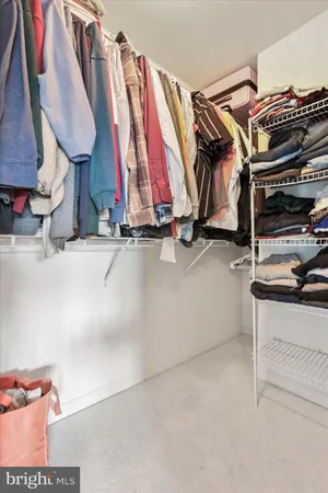 a view of walk in closet with clothes and shoes