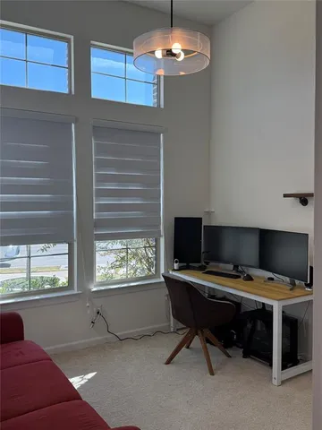 a view of a workspace with furniture and a window