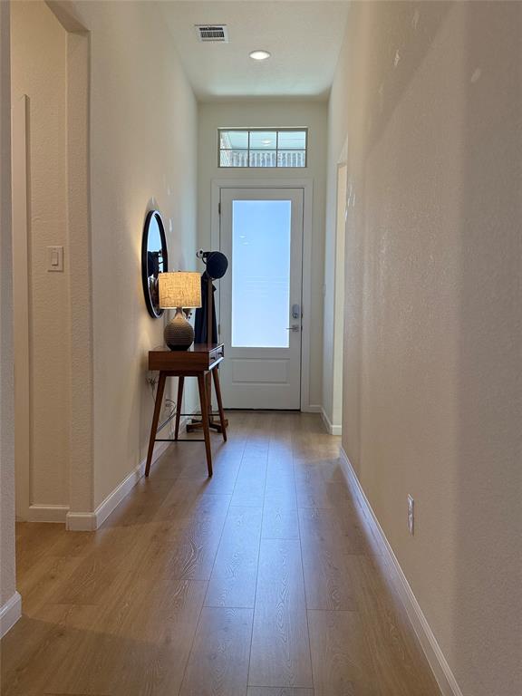 1122 Silverthorne Trail Justin, TX 76247 - Photo 2 of 19 Doorway to outside with a textured wall and wood finished floors