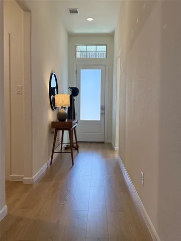 a view of a workspace with wooden floor and a window