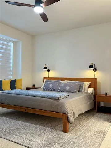 a bedroom with a bed and ceiling fan