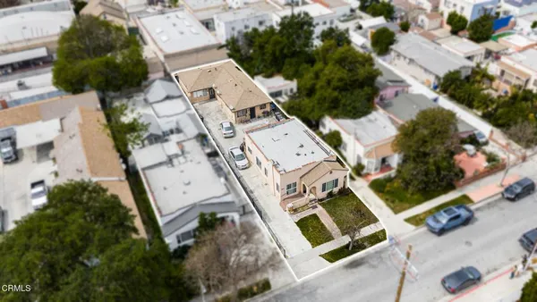 an aerial view of a house with a yard and parking spaces