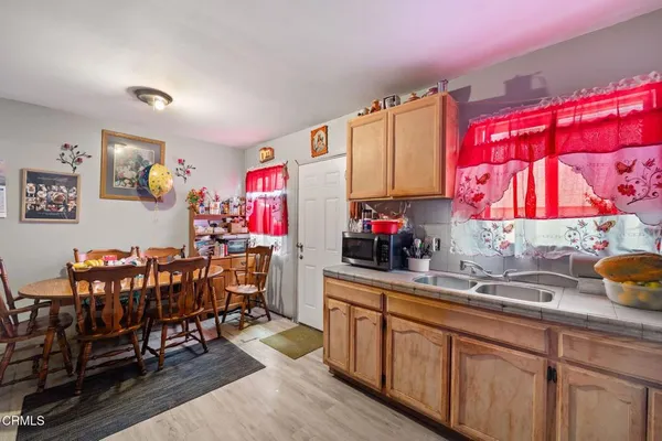 a kitchen with stainless steel appliances a sink dishwasher and cabinets with wooden floor