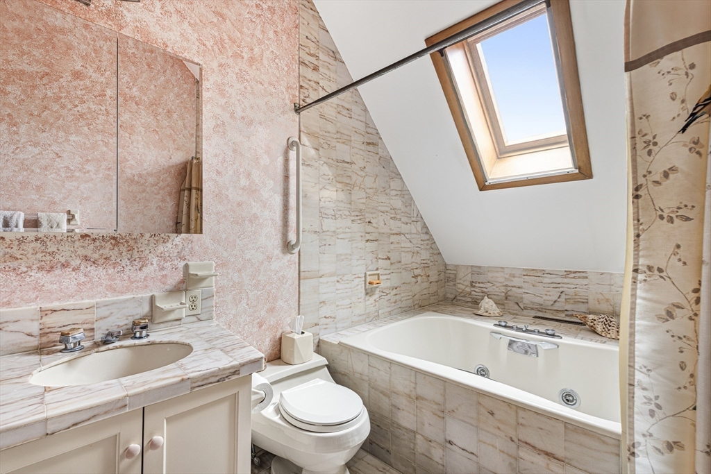94 Howland Road Westport, MA 02790 - Photo 29 of 33 a bathroom with a bathtub sink mirror vanity and toilet