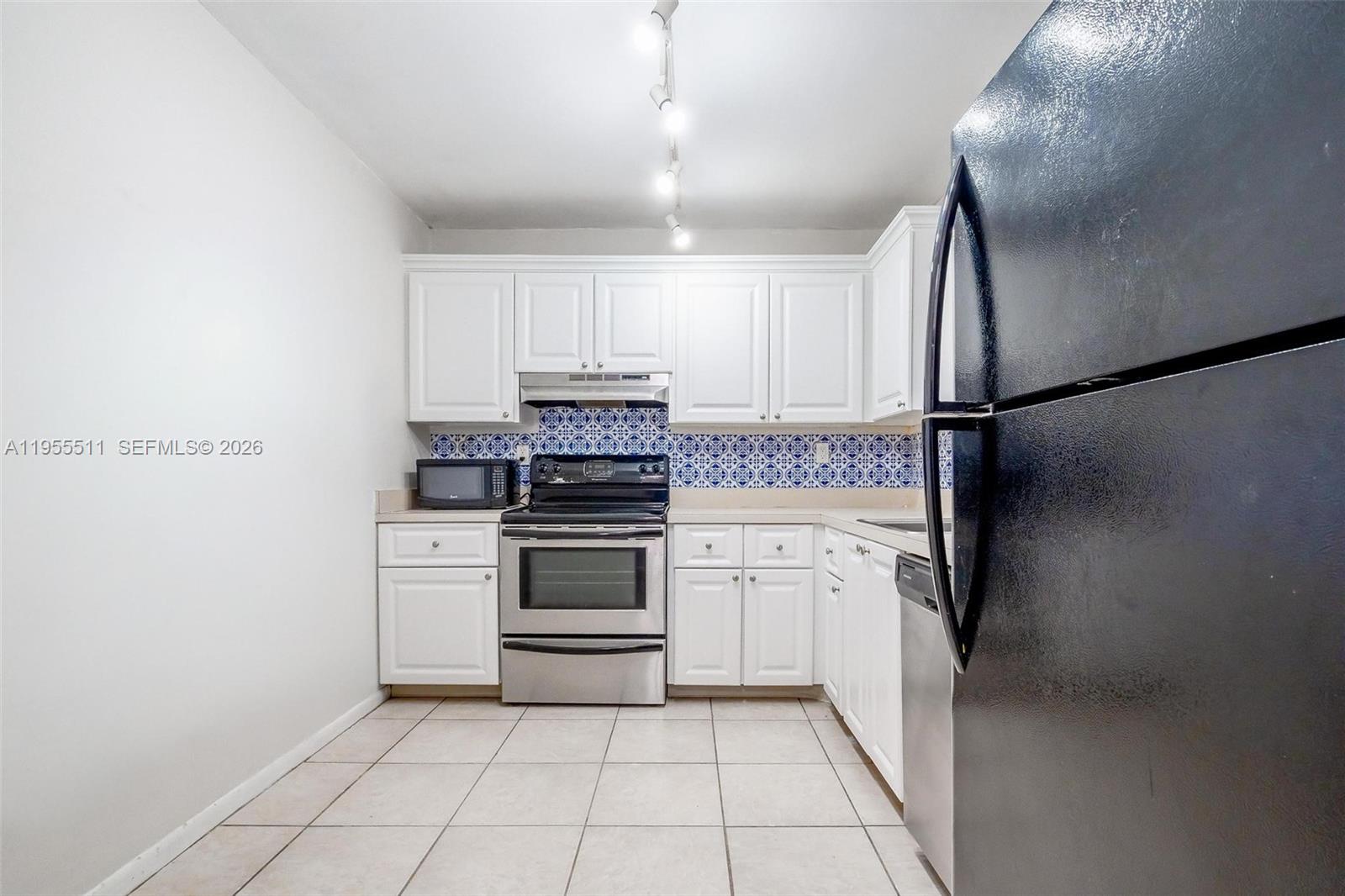 711 North Pine Island Road, Unit 410 Plantation, FL 33324 - Photo 12 of 45 a kitchen with a refrigerator and a sink