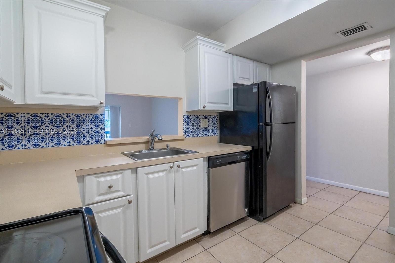711 North Pine Island Road, Unit 410 Plantation, FL 33324 - Photo 13 of 45 a kitchen with stainless steel appliances granite countertop a refrigerator a sink and white cabinets