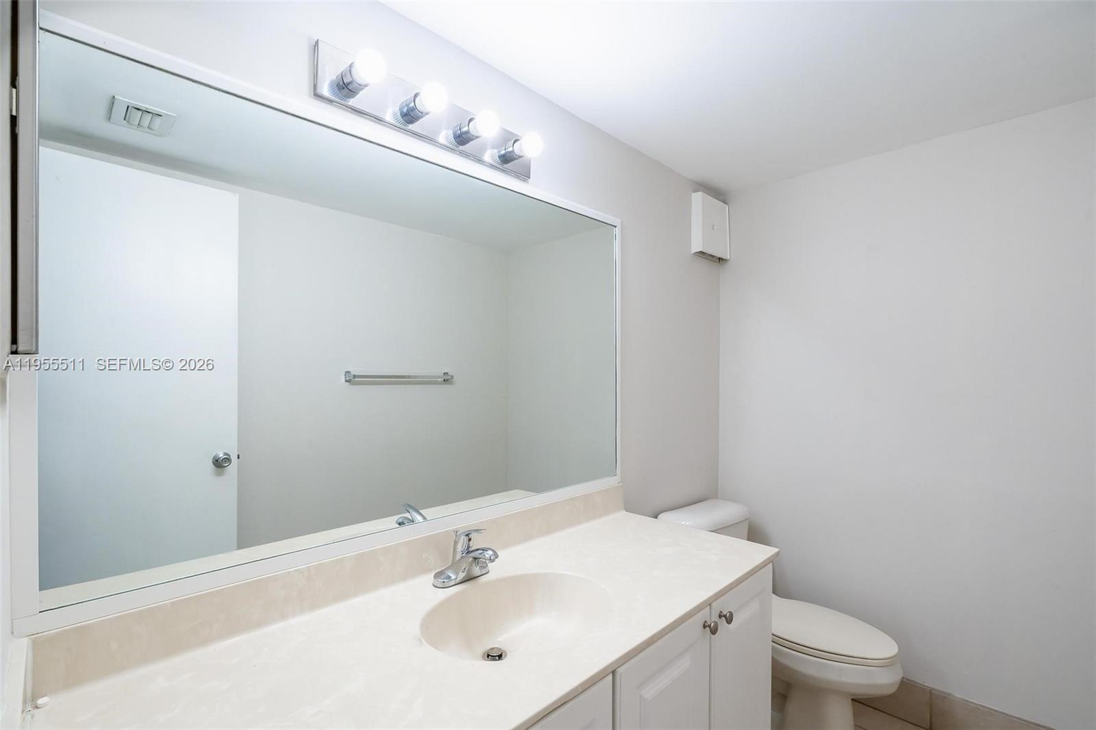 711 North Pine Island Road, Unit 410 Plantation, FL 33324 - Photo 15 of 45 a bathroom with a sink a toilet and a mirror