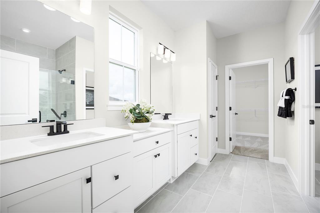 22174 Pine Grove Loop Leesburg, FL 34748 - Photo 7 of 8 a spacious bathroom with double sink a shower and a mirror