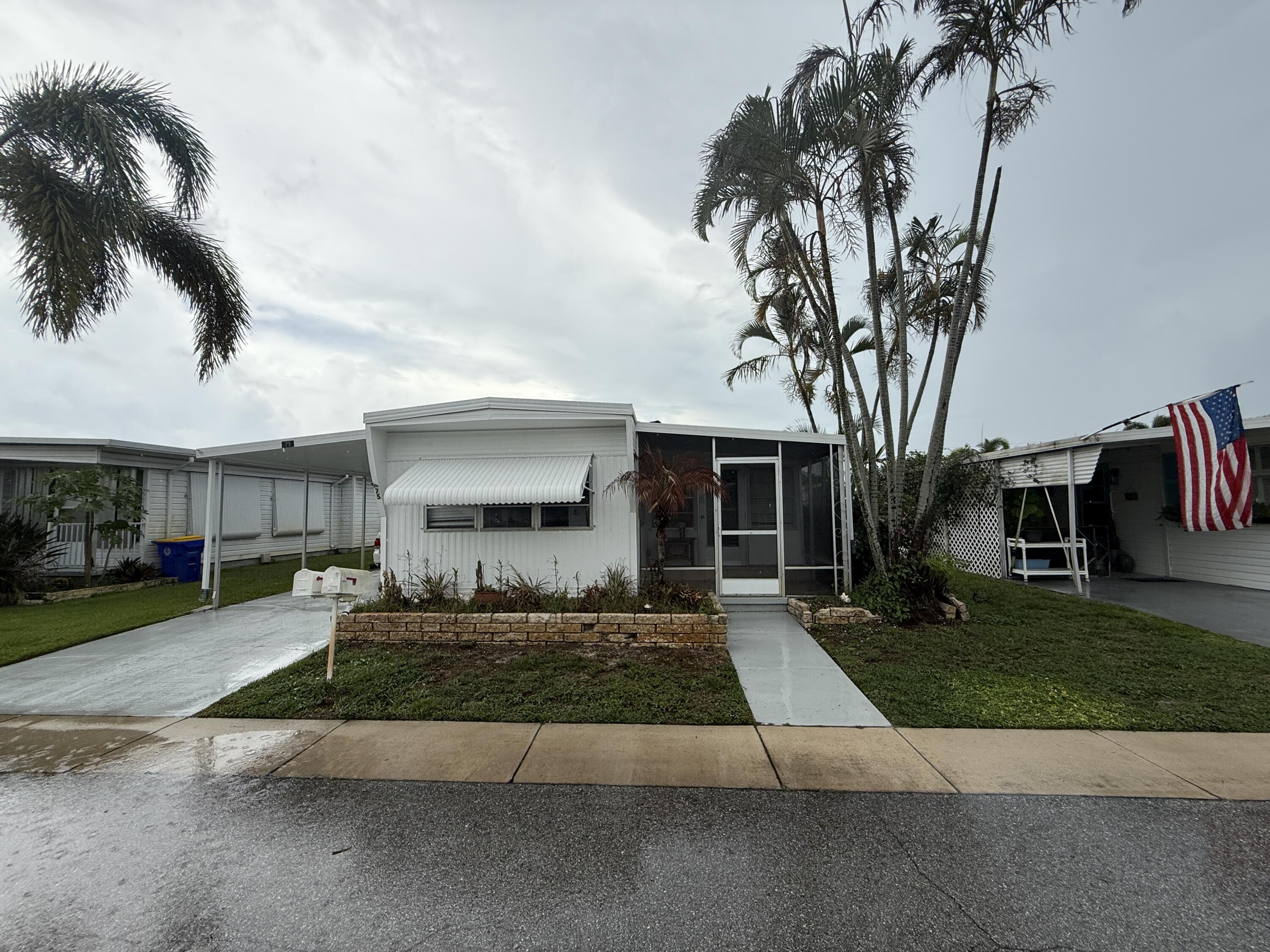 a front view of a house with a yard and potted plants