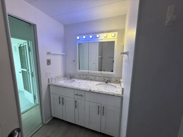 a bathroom with a granite countertop sink vanity and mirror