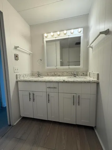a bathroom with a granite countertop toilet and a shower