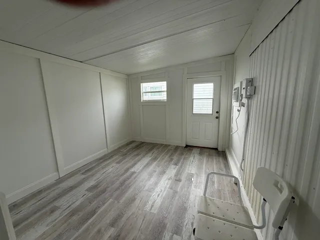 a view of a room with wooden floors and window