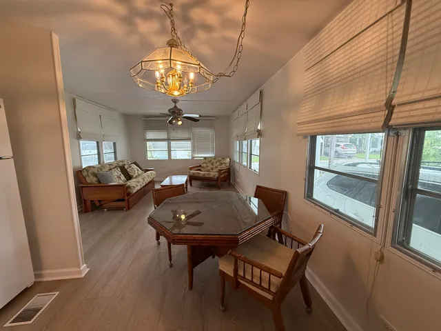 a view of a dining room with furniture a chandelier and wooden floor
